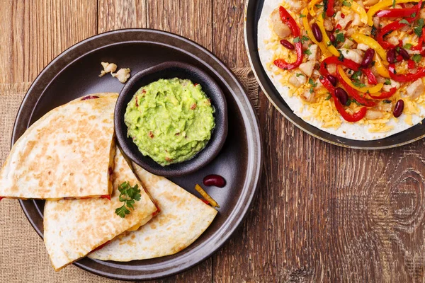 Quesadilla with chicken, served with guacamole or salsa sauce.