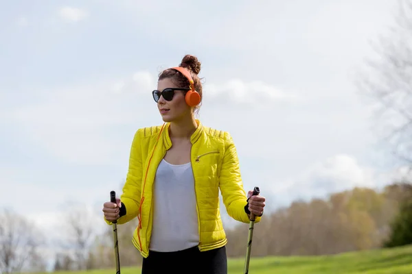 Kvinna i gul jacka och svarta leggings tränar nordisk wa — Stockfoto