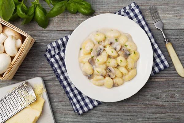 Portie gnocchi met champignonsaus en kaas. — Stockfoto