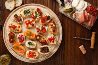 Ahşap arka planda farklı malzemelerle Crostini. Lezzetli aperatifler. Üst görünüm.