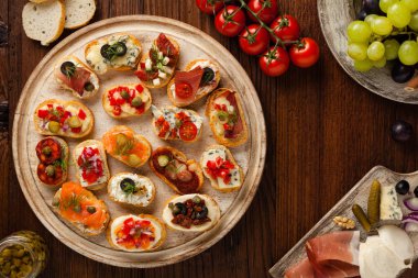 Ahşap arka planda farklı malzemelerle Crostini. Lezzetli aperatifler. Üst görünüm.
