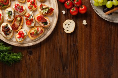 Ahşap arka planda farklı malzemelerle Crostini. Lezzetli aperatifler. Üst görünüm.