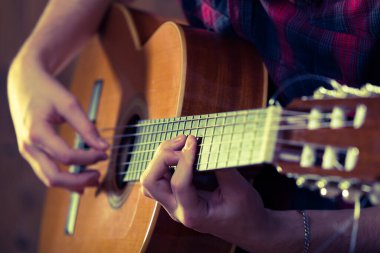 Bir konser sırasında akustik gitar çalan genç bir adam. - Eski renkler..