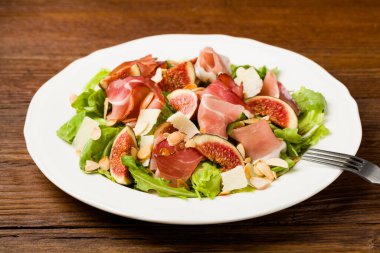 İncirli taze salata ve parmesan peynirli jambon ve kızarmış badem. Ön görünüm.