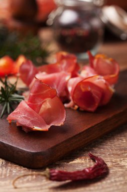 Baharatlı ahşap bir tahtada lezzetli prosciutto jambon.