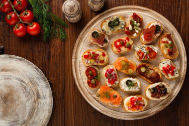 Ahşap arka planda farklı malzemelerle Crostini. Lezzetli aperatifler. Üst görünüm.