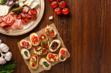Ahşap arka planda farklı malzemelerle Crostini. Lezzetli aperatifler. Üst görünüm.