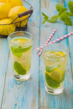 Nane şekerli limonata ve bir bardakta servis edilen ahşap bir masada pipetle..