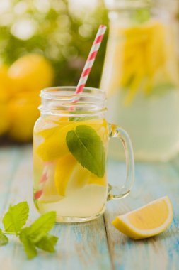 Nane şekerli limonata ve bir kavanozda servis edilmiş tahta bir masada pipetle..