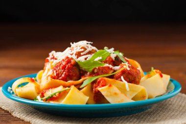 Domates soslu köfteli İtalyan makarnası. Peynir ve roka serpiştirilmiş. Ön görünüm