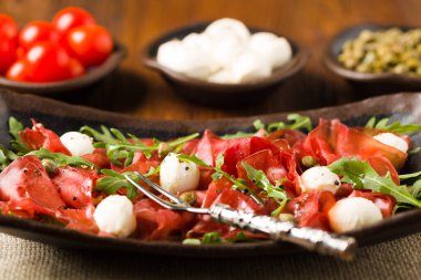 Biftek carpaccio mozzarella peyniri, roka ve kapari ile servis edilir. Ön manzara. Yakın plan..