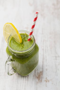 Taze narenciye ve ıspanakla birlikte kavanozda servis edilen sebze ve meyve kokteyli..