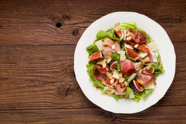 İncirli taze salata ve parmesan peynirli jambon ve kızarmış badem. Üst görünüm.