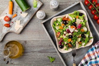 Siyah zeytinli ve parmesanlı taze sebzeli İtalyan salatası. Antika manzara.