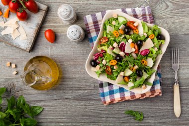 Siyah zeytinli ve parmesanlı taze sebzeli İtalyan salatası. Antika manzara.