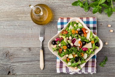 Siyah zeytinli ve parmesanlı taze sebzeli İtalyan salatası. Antika manzara.