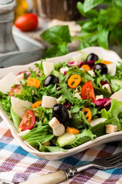 Siyah zeytinli ve parmesanlı taze sebzeli İtalyan salatası. Antika manzara.