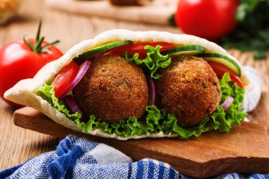 Falafel ve taze sebzeler ahşap masada pide