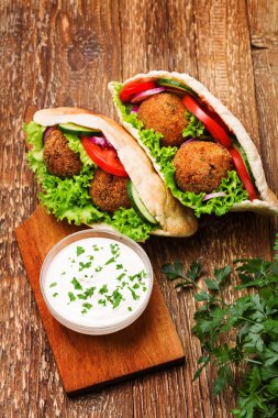 Falafel ve taze sebzeler ahşap masada pide