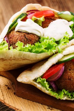 Falafel ve taze sebzeler ahşap masada pide
