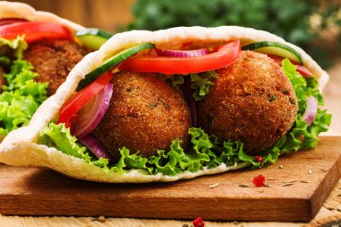 Falafel ve taze sebzeler ahşap masada pide