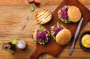 Kırmızı soğan ve marullu ördek etli hamburger..