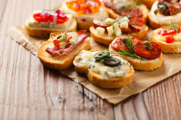 Crostini Med Olika Toppar Trä Bakgrund Utsökt Förrätt Framifrån — Stockfoto