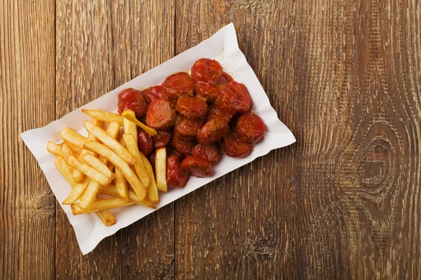 Tradiční Německý Currywurst Podávaný Hranolkami Jednorázovém Papírovém Podnosu Dřevěný Stůl — Stock fotografie