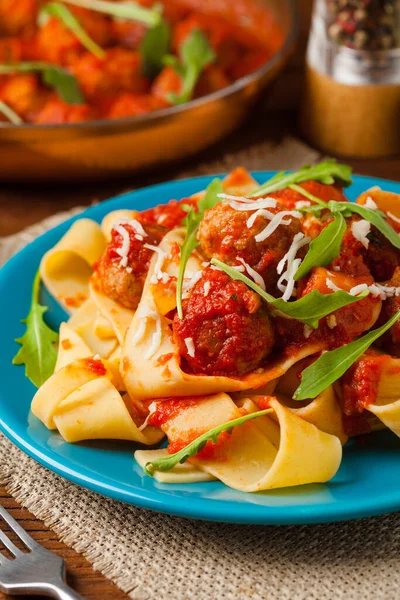 トマトソースのミートボールとイタリアのパスタパパルデッレ チーズとアルグラを振りかけた 正面図 — ストック写真