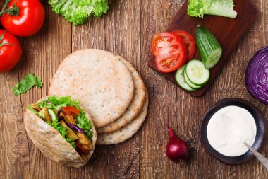 Kızarmış tavuk ve sebzeli Pita salatası, lezzetli bir sosla servis edilir.