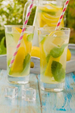 Nane şekerli limonata ve bir bardakta servis edilen ahşap bir masada pipetle..