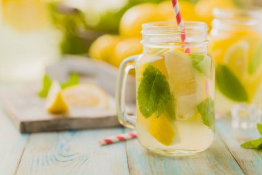 Nane şekerli limonata ve bir kavanozda servis edilmiş tahta bir masada pipetle..