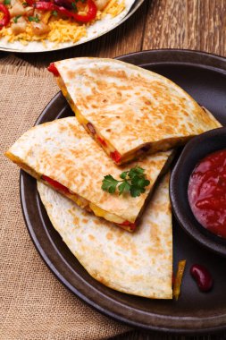 Tavuk ile Quesadilla, guacamole veya salsa sosuyla servis edilir..