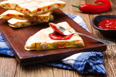 Tavuk ile Quesadilla, guacamole veya salsa sosuyla servis edilir..