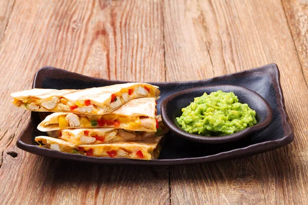 Quesadilla with chicken, served with guacamole or salsa sauce.