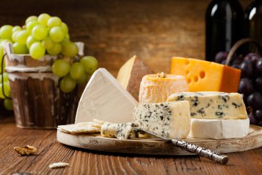 Tahta tahtada peyniri üzümle karıştır. Ön görünüm.