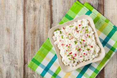 Taze süzme peynir, taze sebze ve kremayla servis edilir. Üst görünüm.