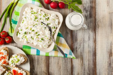 Taze süzme peynir, taze sebze ve kremayla servis edilir. Üst görünüm.