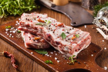 Baharatlı bir tabakta çiğ domuz pirzolası. Ön görünüm.