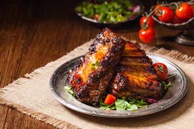 Kızarmış pirzola, eski bir tabakta servis edilir. Fron manzaralı. Koyu veya kel arkaplan.