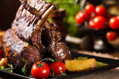 Fırında kuzu fileto, kuşkonmazla servis edilir. Koyu arkaplan.