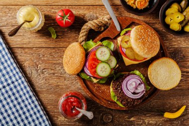 Ev yapımı, peynirli ve sebzeli sığır burger. Üst görünüm.