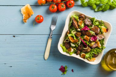 Kızarmış tavuk ciğeri ve tost ile sıcak salata. Üst görünüm.