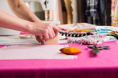 Dikiş atölyesi. Dikiş battaniyesini hazırlıyorum. Materyali çiziyorum. Terzi kesmek için bir şablon çizer.