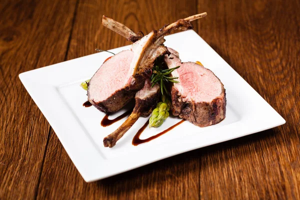 Baked lamb loin, served with asparagus. Dark background.