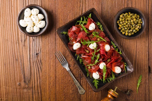 牛肉卡帕西奥与莫扎拉奶酪 阿鲁古拉和卷心菜球一起食用 顶部视图 — 图库照片