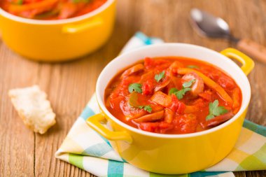 Taze sebzeli leziz Letcho, taze ekmekle birlikte sarı bir tencerede servis ediliyor..