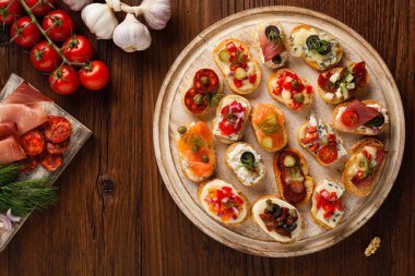 Ahşap arka planda farklı malzemelerle Crostini. Lezzetli aperatifler. Üst görünüm.