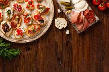 Ahşap arka planda farklı malzemelerle Crostini. Lezzetli aperatifler. Üst görünüm.