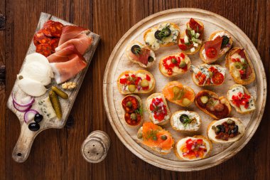 Ahşap arka planda farklı malzemelerle Crostini. Lezzetli aperatifler. Üst görünüm.